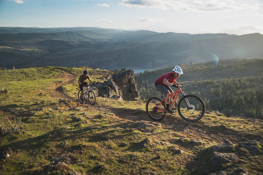 Mountain bikers on Specialized Rockhopper bikes navigating a dirt trail