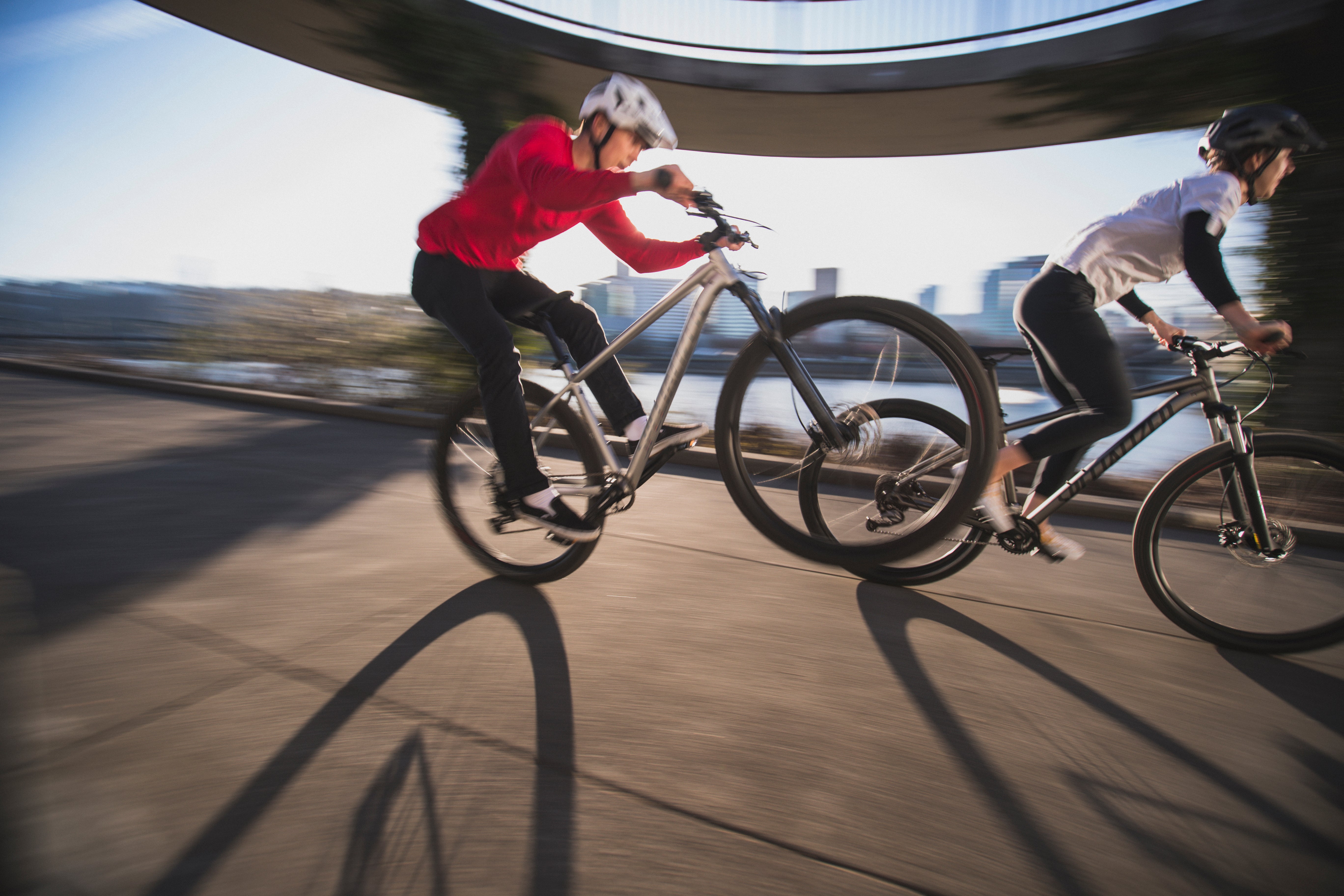 Two riders performing wheelies on Specialized Rockhopper mountain bikes