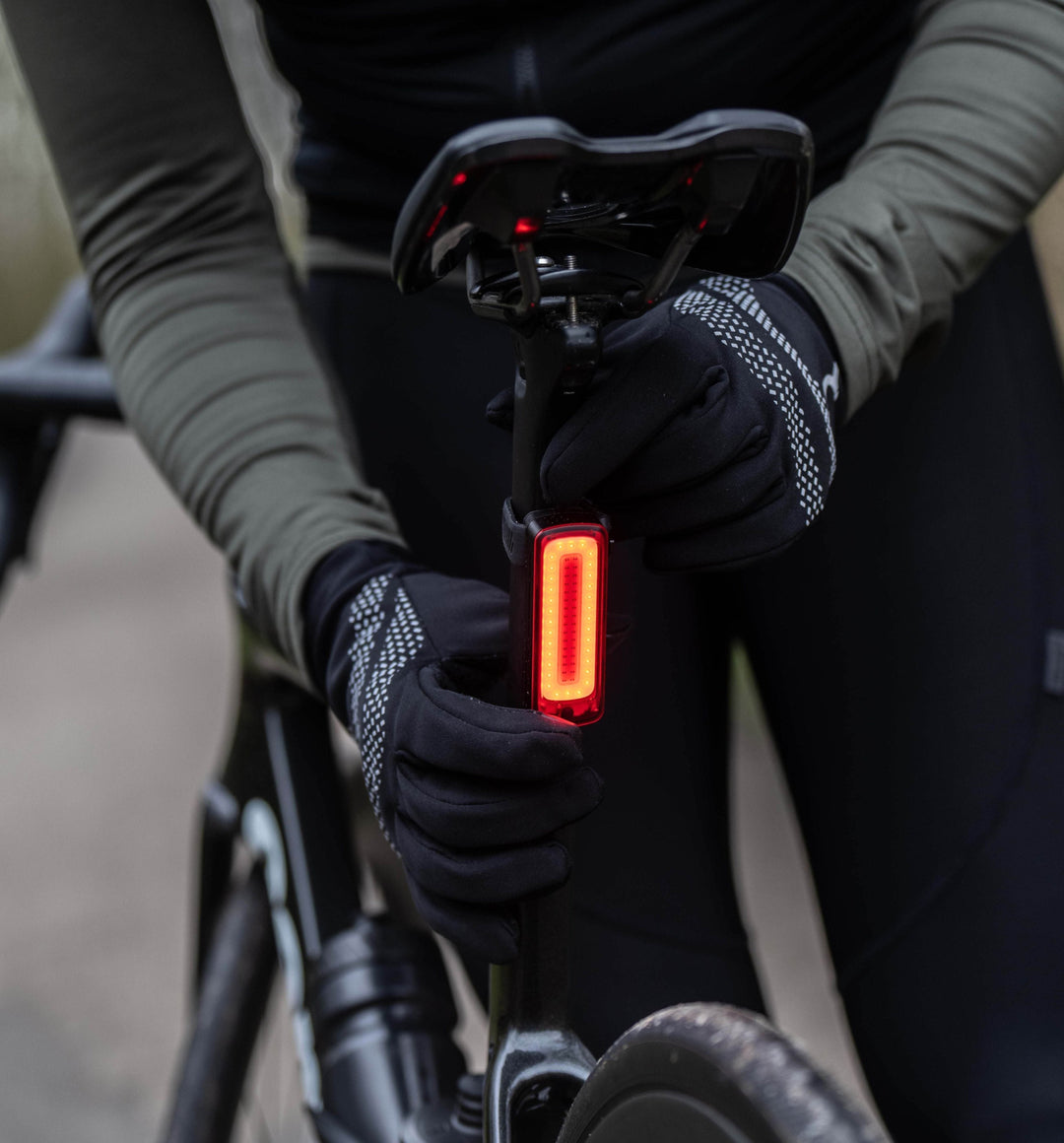 person installing rear bike light to their bike